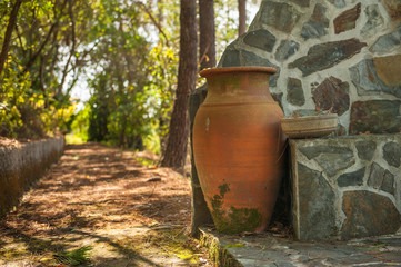 An old garden pot, made of baked clay. Very nice rustic like, old garden jar, a replica of ancient Greece pots, settled in the quite part of garden waiting for new flowers to be put in.