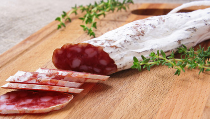 salami slicing with thyme on board