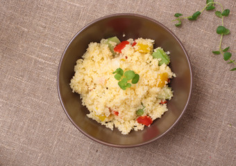 Couscous and roasted vegetables salad in a brown dish