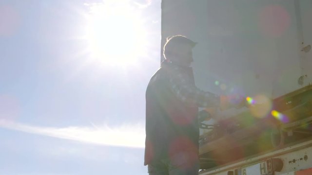 Truck Driver Closes Doors of His  Truck Cargo Trailer. Professional Driver Wears Heavy Duty Gloves.  Shot on RED EPIC-W 8K Helium Cinema Camera.