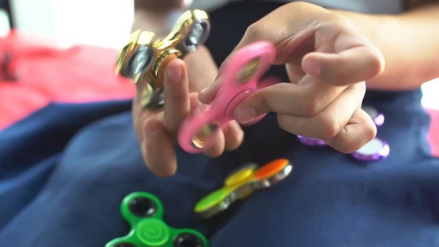 Teenage playing with fidget spinner.
