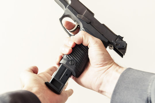 Point of view loading a clip into a handgun