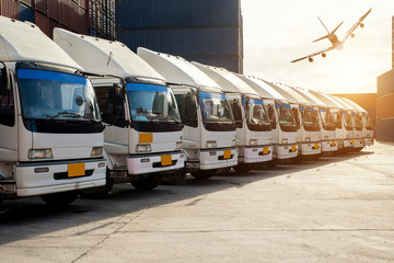 Container truck and Cargo airplane in depot at porrt. Logistics import export background and...