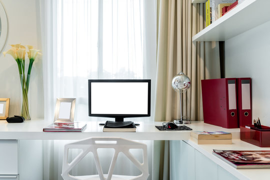 Computer display and office tools on desk in home. Desktop computer screen isolated. Modern creative workspace background. Workspace at home.