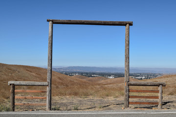 Old Wooden Framed Entrance to Farmland, with a blue sky and mountain range in the distance - 167416820