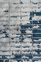 Blue & white paint peeling off a brick wall