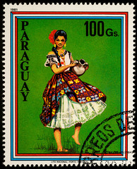 Young woman with jug in traditional dress on postage stamp