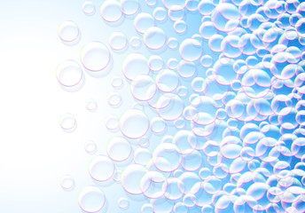 Soap bubbles abstract blue background with rainbow colored airy foam