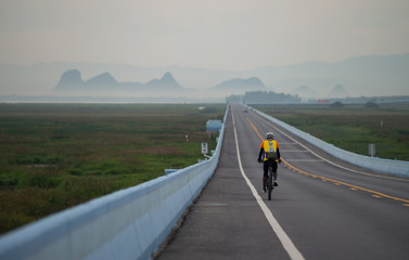 Cycling on the longest bridge in the morning at Thale noi, Phatthalung, Thailand.
