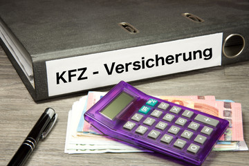 Euro Geldscheine, Taschenrechner und ein Ordner mit dem Aufdruck KFZ Versicherung