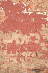 Red Paint Peeling off old orange Brick Wall