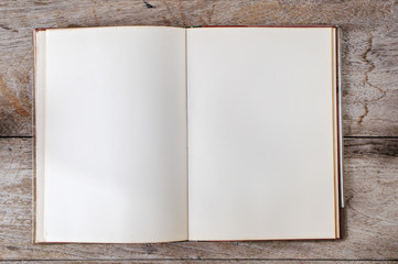 Flat lay of old open book on wooden background