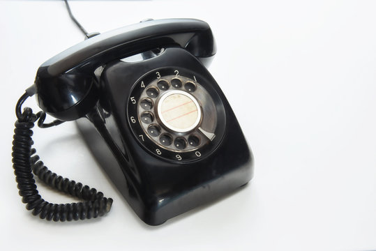 Vintage black telephone on white background, selective focus idea