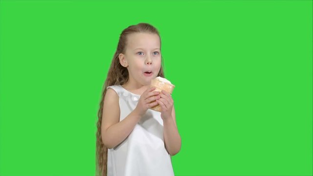 Kid girl eating with ice cream on a Green Screen, Chroma Key