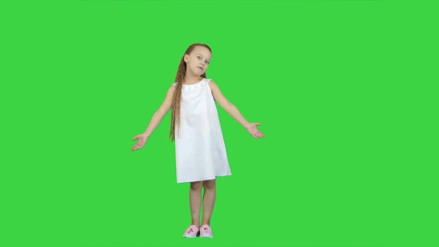 Young lady is dressed up in lovely dress and white shoes singing a song on a Green Screen, Chroma Key
