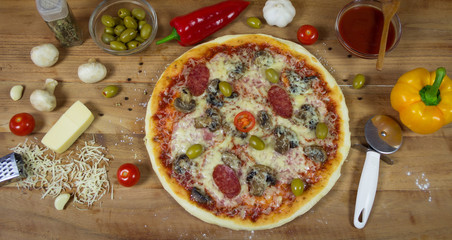 Hot appetite baked pizza with a variety of attachments on the wooden table