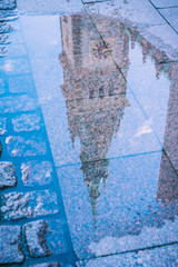 Reflection of City Hall Tower in a puddle. Hamburg, Germany