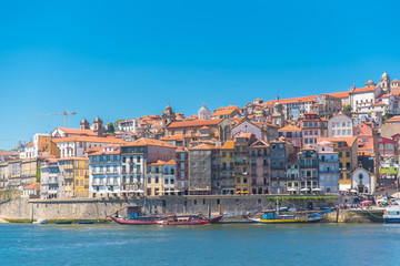 Fototapeta na wymiar Porto in Portugal, the river Douro, colored buildings with tiles roofs and traditional boats 