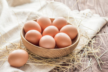 Chicken eggs in a basket with hay - 167430024