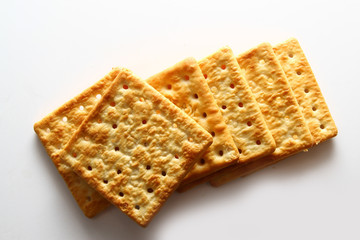 A cracker is a baked food typically made from flour. Flavorings or seasonings, such as salt, herbs, seeds, and/or cheese, may be added to the dough or sprinkled on top before baking