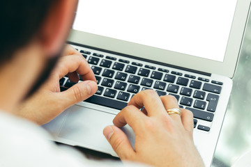 Young man performs work on a laptop