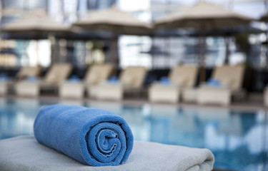 towel rolled up ready for guests at a swimming pool in an early morning