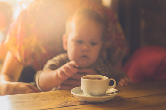 Baby reaching for cup of coffee