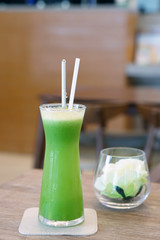Closeup glass of cold pressed juice on wooden table, Fresh mixed fruits made from Gotu kola, Curcuma, Guava and Pineapple, Healthy drink concept.