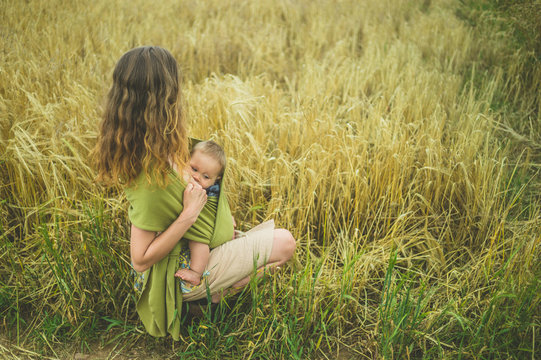 Mother breastfeeding baby in field