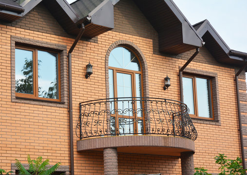 Beautiful metal balcony. Brick house.