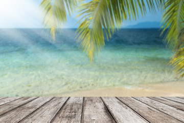 Fototapeta na wymiar Blur beautiful nature green palm leaf on tropical beach with sun light wave abstract background.