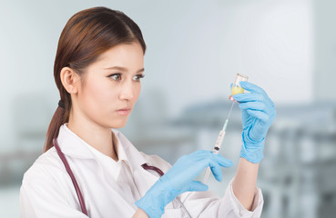 Syringe with vial  on hands in a latex glove of a female  doctor,administer the injection.