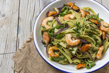 Green tagliatelle with seafood. Mussels; Prawns