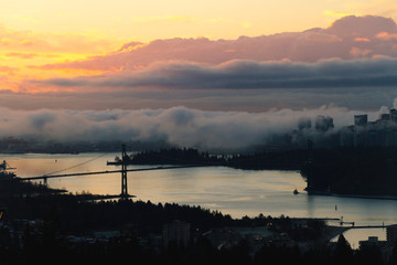 Fototapeta na wymiar Colorful sunrise in city in clouds and fog