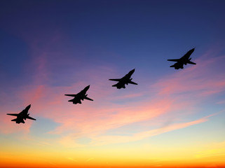 Fototapeta na wymiar Silhouette of russian combat aircrafts with sunset sky on a background