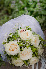 Wedding rings on a wedding bouquet. White roses and rings.