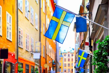 Fotobehang Straat in Stockholm met Zweedse vlaggen © Roman Sigaev