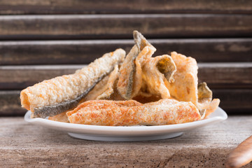 Crispy fried salmon skin on wood background