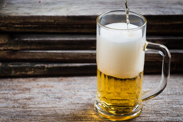 mug of beer on wood background