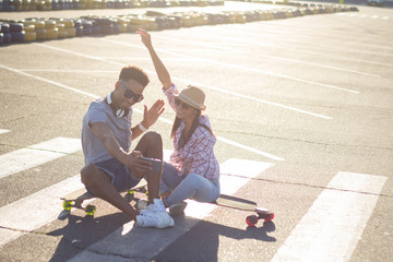 Young couple riding skateboard during sunrise 