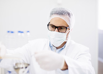 Close up portrait of male scientist with mask and glasses in laboratory.