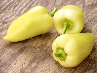 Whole fresh yellow bulgarian peppers. On wooden background