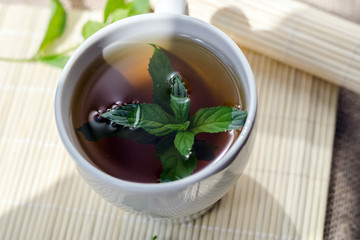 Cup of mint tea and a bunch of mint on the table