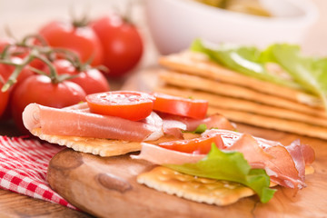 Crackers with ham and avocado. 