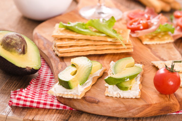 Crackers with ham and avocado. 