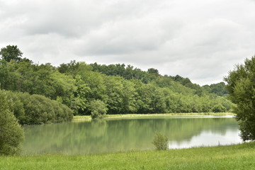 Le grand &eacute;tang aux couleurs &eacute;meraudes entour&eacute; de for&ecirc;ts sous un ciel gris ,pr&egrave;s de Champagne, au P&eacute;rigord Vert