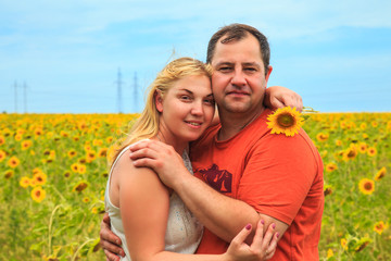 Loving couple in a field of sunflowers.