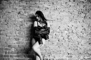 Brunette plus size sexy woman, wear at black leather jacket, lace panties, bra at abadoned place...