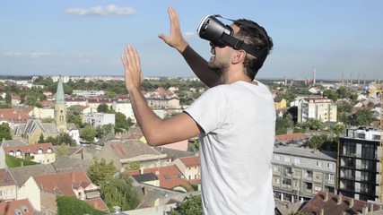 man with virtual reality headset or goggles touching screen or camera, imagined and dreaming different world and technology, love new applications and science - Powered by Adobe