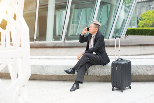 asian senior businessman travel with phone